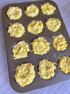 stacking and layering tahchin tahcheen ingredients into a non-stick muffin tray or tin
