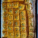 brittle sauce sohan over Saltine crackers sprinkled with green pistachio sliverssohan