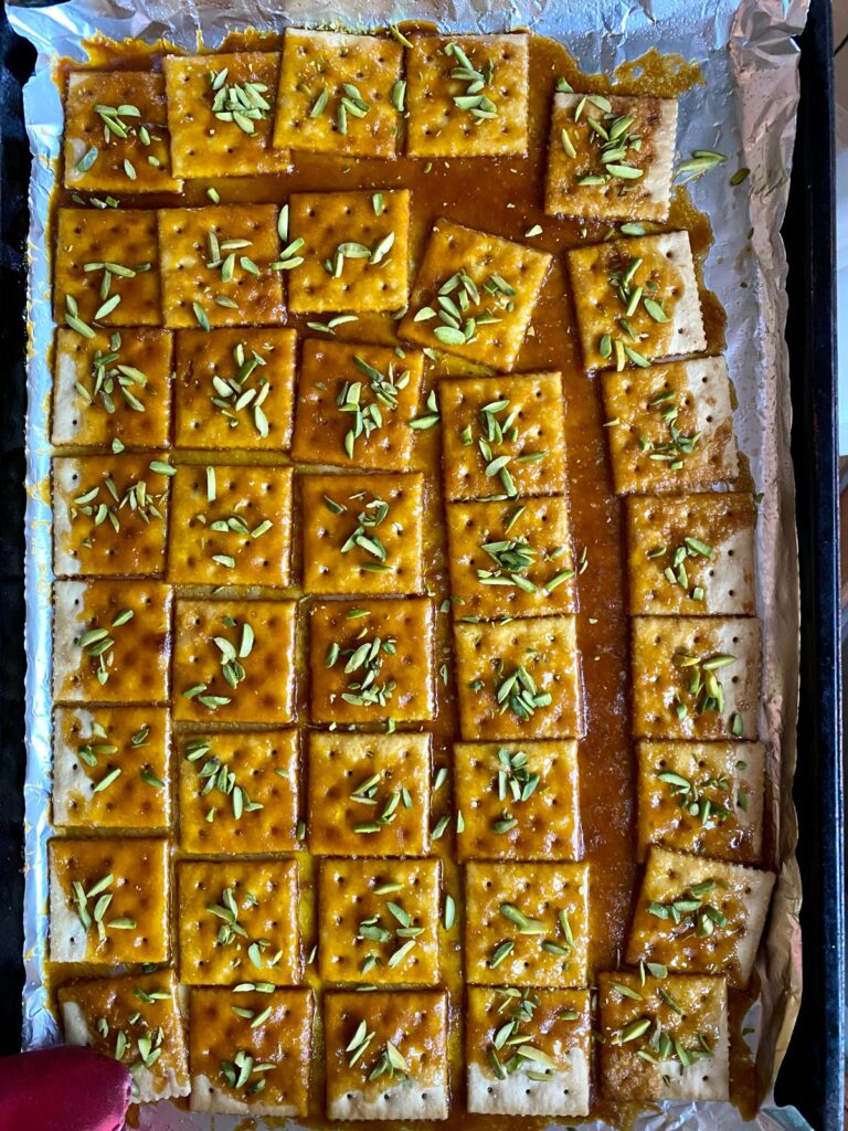 brittle sauce sohan over Saltine crackers sprinkled with green pistachio sliverssohan